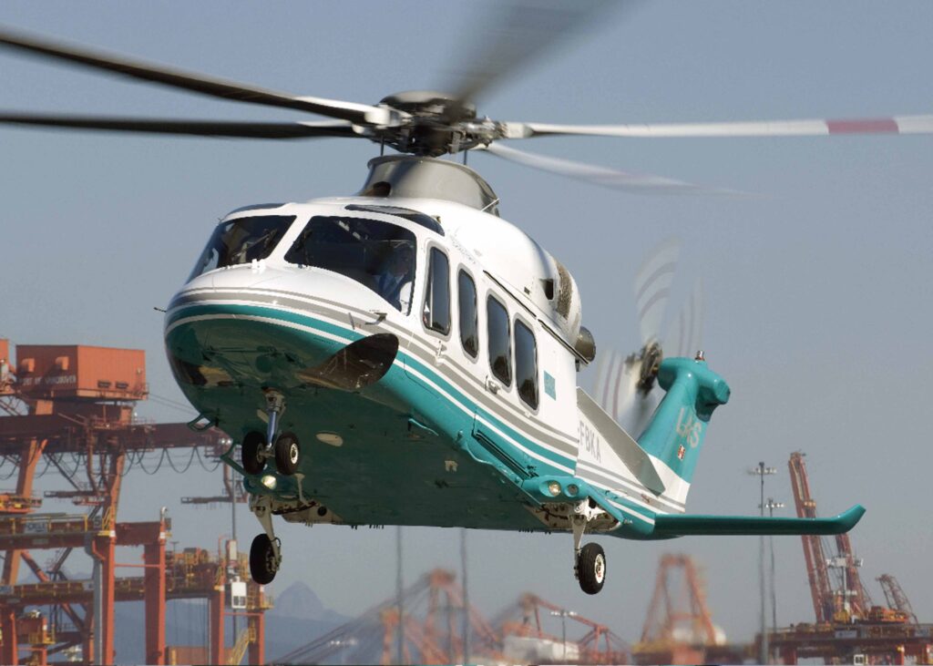 A London Air Services AW139 private charter helicopter taking off from an industrial port in the Pacific Northwest.