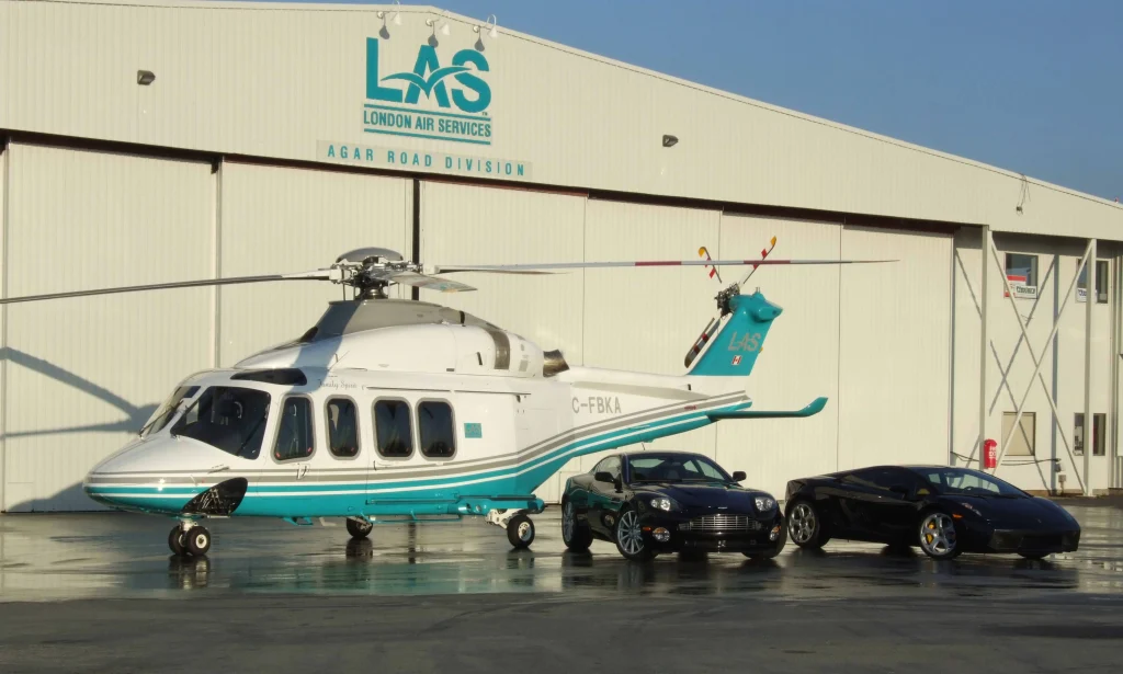 A London Air Services charter helicopter outside the state-of-the-art LAS hangarage facility beside a Maserati and a Lamborghini