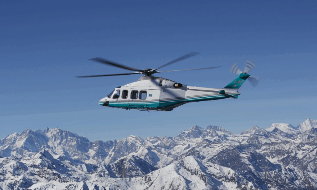 Twin-engine London Air Services AW139 helicopter flying toward Whistler with snowy mountain peaks in the background, showcasing premium alpine charter services across British Columbia.
